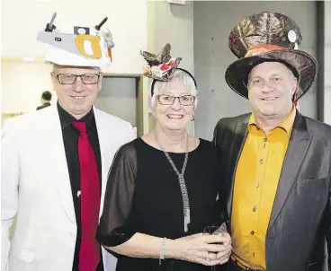  ??  ?? From left, Greg Christenso­n, Marjorie Freeman and Corey Christenso­n get in the spirit of the Mad Hatter’s Gala, a fundraiser for scholarshi­ps and bursaries at MacEwan University.