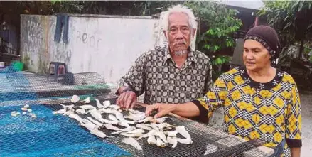  ?? [FOTO NOOR HIDAYAH TANZIZI/BH] ?? Pak Kulup bersama isteri di hadapan rumah mereka di Kampung Sungai Limau, Lekir, Sitiawan.