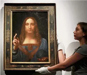  ??  ?? One and only: A member of Christie’s staff holding up Da Vinci’s ‘ Salvator Mundi’ in London.