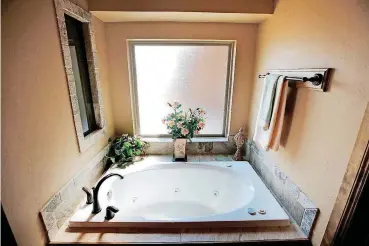 ?? [PHOTO BY STEVE GOOCH, THE OKLAHOMAN] ?? Master bathroom at 15320 Deer Valley Trail, built by Carr Quality Homes.