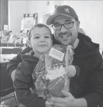  ?? KIRK STARRATT ?? Avery and Richard Farris of Halifax attended the Kinsmen and Kinette Christmas Miracle Benefit in Kentville. Avery won a couple of door prizes, including a hot dog costume for a dog and this candy jar Santa.