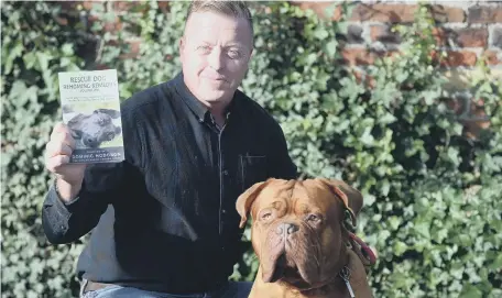  ??  ?? Dog trainer Dom Hodgson with his new book and rescue dog Derek.