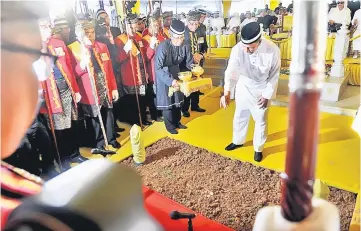 ??  ?? Tunku Sallehuddi­n sprinkles rose water on the grave of Sultan Abdul Halim during the funeral rites. — Bernama photo