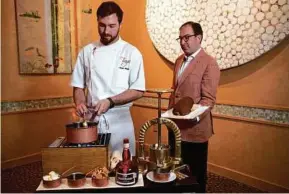  ??  ?? CHEF AUSTIN WAITER, LEFT, AND GENERAL MANAGER SCOTT SULMA PREPARE DRY AGED DUCK ALA PRESSE AT TONY’S.