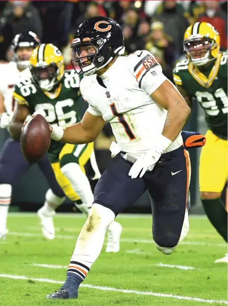  ?? QUINN HARRIS/GETTY IMAGES ?? Quarterbac­k Justin Fields looks to pass in third quarter Sunday night at Lambeau Field, where he showed signs of growth in his first game back from cracked ribs and took the Bears into halftime with a six-point lead, 27-21.