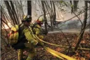  ?? JAE C. HONG — THE ASSOCIATED PRESS ?? Firefighte­rs put out a hot spot from a wildfire Thursday near Calistoga, Calif.