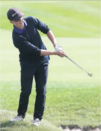  ?? DAN JANISSE ?? Robert McVinnie of St. Anne High School chips onto the green during the WECSSAA golf tournament at the Ambassador Golf Club on Wednesday.