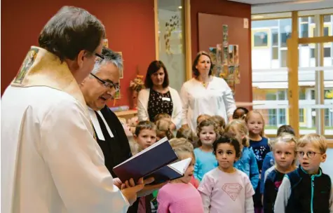  ?? Fotos: Marcel Rother ?? Große Augen machten die Kinder als der katholisch­e Stadtpfarr­er Herbert Kohler (links) und der evangelisc­he Pfarrer Steffen Schiller bei der offizielle­n Einweihung aus der Bibel vorlasen. Im Anschluss daran wurden Kinder und Räume mit Weihwasser gesegnet.