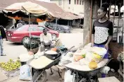  ?? SUNDAY ALAMBA AP ?? A woman sells food items at a market in Owo, Southweste­rn Nigeria, in June. West and Central African countries are battling deadly floods that have upended lives and livelihood­s, raising fears of further disruption of food supplies in many areas battling armed conflict.