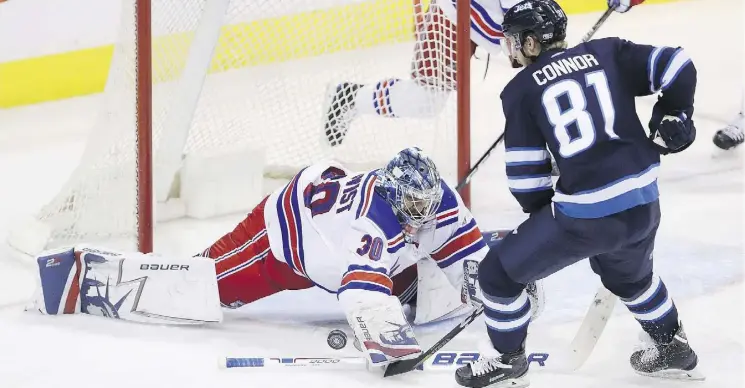  ?? TREVOR HAGAN/THE CANADIAN PRESS ?? New York Rangers goaltender Henrik Lundqvist dives to stop Winnipeg Jets winger Kyle Connor during the third period on Sunday in Winnipeg.