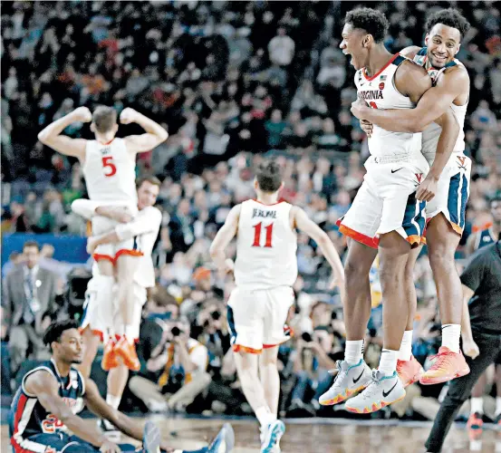  ?? CHARLIE NEIBERGALL/AP ?? Virginia players celebrate after their 63-62 victory over Auburn in the first of two national semifinals Saturday in Minneapoli­s.