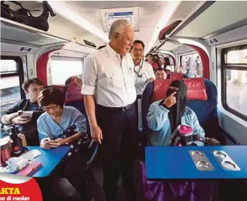  ??  ?? NAJIB beramah mesra dengan penumpang ketika menaiki kereta api ETS menuju ke Tanjung Malim dari Stesen KL Sentral, semalam.