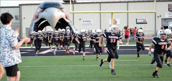  ?? TIMES photograph by Annette Beard ?? Pee Wee Blackhawks ran out of the Hawk head tunnel behind the varsity Blackhawks Friday, Sept. 10, 2021, before the game against Prairie Grove.