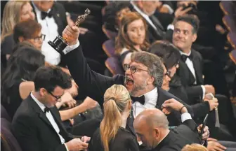  ?? PHOTOS BY ROBERT DEUTSCH/ USA TODAY NETWORK ?? Guillermo del Toro shows off the first of his two Oscars won at Sunday’s Academy Awards.