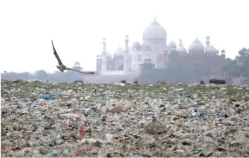  ?? — Reuters file photo ?? Garbage is seen on the polluted banks of the river Yamuna near the historic Taj Mahal in Agra.