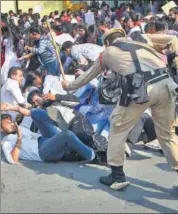  ??  ?? From left: College students and locals burn tyres in Tinsukia; policemen use batons to disperse the students protesting against the CAB in Guwahati, Assam, on Wednesday.
PTI