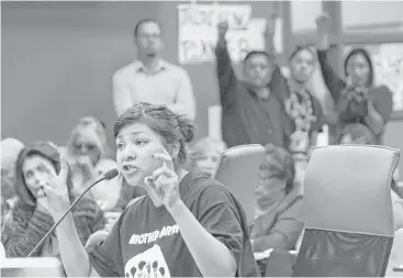  ?? Susan Montoya Bryan photos / Associated Press ?? Ahjani Yepa, a Jemez Pueblo member, testifies in opposition of a proposed ordinance that would govern oil and gas developmen­t in Sandoval County as others raise their fists in solidarity in Bernalillo, N.M.