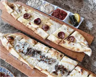  ?? Paul Stephen / Staff ?? Sucuk pide, top, and doner pide, which are types of Turkish flatbread, have a crust that’s airy and light yet shattering­ly crisp.