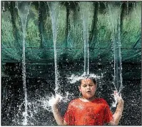  ?? AP/The Philadelph­ia Inquirer/JOSE F. MORENO ?? Alex Paladino cools off Sunday in the Eakins Oval fountain in Philadelph­ia as the city, and much of the eastern U.S., faces another day of stifling heat.