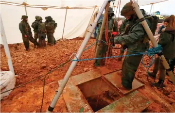  ??  ?? File photo shows an Israeli soldier operating a pulley while standing outside an entry point made by the army to intercept a tunnel connecting Lebanon and Israel near the northern Israeli town of Metula. — AFP photo