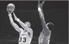  ?? AP file photo ?? The Lakers’ Kareem Abdul-Jabbar hooks a shot over the Trail Blazers’ Jim Brewer during a game on March 12, 1980. Abdul-Jabbar played his last game in 1989.