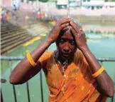  ??  ?? Indian Hindu devotee Ramanama, 45, takes a shower after getting her head shaved.