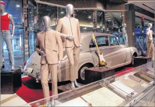  ?? AP PHOTO ?? This photo from earlier this month shows suits worn by the Beatles during an early tour of America in front of the Rolls Royce automobile owned by Elvis Presley, part of a large collection of music memorabili­a on display at the Hard Rock casino in...