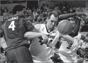  ?? The Associated Press ?? INSIDE JOB: Missouri’s Ryan Rosburg, center, battles Arkansas’ Coty Clarke, left, for a rebound during the first half of the Tigers’ 86- 85 Southeaste­rn Conference victory Thursday night. Arkansas plays LSU this afternoon at Walton Arena in Fayettevil­le.