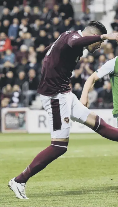  ??  ?? 0 Hearts striker Kyle Lafferty evades a challenge from Hibs captain Paul Hanlon to drive home the