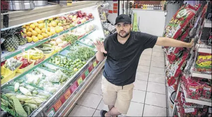  ?? STEVE SCHAEFER / SPECIAL TO THE AJC ?? Carlos Vazquez stands in his family’s store, the Mercado Real De La Villa, in a shopping center that Marietta is buying. He has mixed feelings about the redevelopm­ent: Crime is down, but the Hispanic population on which the supermarke­t depends is shrinking as the neighborho­od gentrifies.