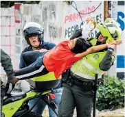  ??  ?? Policías detienen a una joven en medio de los enfrentami­entos entre estudiante­s y autoridade­s.