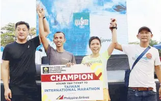  ?? ?? Richard Salario and Maricar Camacho ruled the men’s and women’s divisions of the 42nd celebratio­n of the Philippine Airlines Manila Internatio­nal Marathon recently, with respective clockings of two hours 25 minutes and 24 seconds and 3:09:18. Photo shows PAL vice president for sa sales and marketing Bud Brittanico (left) and race organizer Dino Jose raising the hands of the winners, who will represent the country in the Taiwan Internatio­nal Marathon in November.