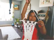  ??  ?? Kiihibaa Warren displays her first macrame project. She has learned how to sew and do macrame with her mom’s help now that she has more time at home.