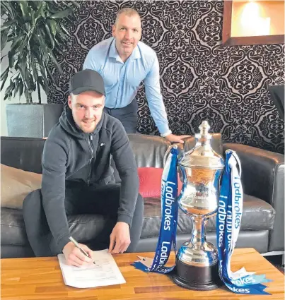  ??  ?? Manager Stewart Petrie looks on as Josh Skelly signs a contract to join Montrose.