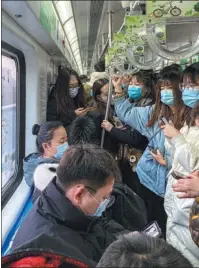  ?? WANG ZHUANGFEI / CHINA DAILY ?? Police officers take passengers’ temperatur­es at the Baimiao checkpoint in Beijing in February.