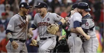  ?? CHARLES KRUPA/THE ASSOCIATED PRESS ?? The Houston Astros’ Yuli Gurriel, left, and Alex Bregman celebrate as catcher Brian McCann hugs closer Ken Giles after eliminatin­g the Boston Red Sox at Fenway Park on Monday. Bregman hit a crucial game-tying home run.