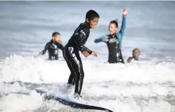  ??  ?? GO FOR IT: A student rides a wave during the surf therapy session. It is to provide safe spaces, caring mentors and a provision of weekly ‘Surf Therapy’ sessions to give vulnerable children skills to cope with life’s challenges.