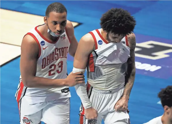  ?? JOSHUA A. BICKEL/COLUMBUS DISPATCH ?? Ohio State forward Zed Key (23) and guard Duane Washington Jr. leave the court after an overtime loss to Oral Roberts.