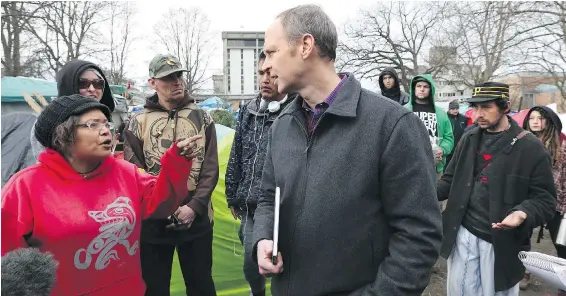  ??  ?? Advocate Christine Brett confronts Jon Burbee, representi­ng the B.C. government, after a notice to leave went to tent city residents on Friday.