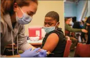  ?? RAY CHAVEZ — BAY AREA NEWS GROUP ?? Registered nurse Kris Del Rosario, left, administer­s a COVID-19vaccine to 12-year-old Kahreem Harris at a school in Richmond. Despite efforts to make vaccines available, Black and Latino youths lag in COVID-19 vaccinatio­n rates compared with White and Asian cohorts.