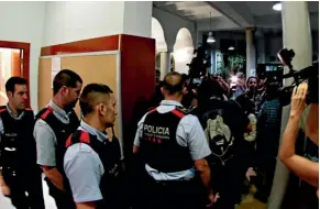  ??  ?? Catalan regional police enter a polling station at a Barcelona high school to remove people who occupied it in a bid to allow voting in the banned independen­ce referendum.