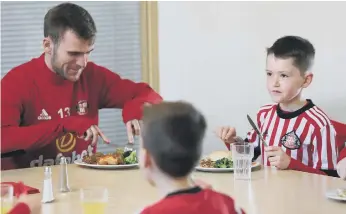  ??  ?? Callum McManaman sits down for lunch with Sunderland’s new intake of Under-9s.