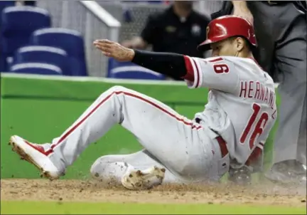  ?? LYNNE SLADKY — THE ASSOCIATED PRESS ?? Philadelph­ia Phillies’ Cesar Hernandez (16) scores on a single hit by Nick Williams during the 12th inning of a baseball game against the Miami Marlins, Sunday in Miami. The Phillies won 3-1.