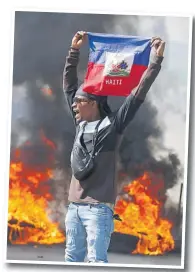 ?? Picture: AP ?? A demonstrat­or holds up an Haitian flag during protests demanding the resignatio­n of Prime Minister Ariel Henry in Port-au-Prince, Haiti, Friday, March 1, 2024.