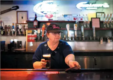  ?? RAY CHAVEZ — STAFF PHOTOGRAPH­ER ?? Cheryl Thies, co-owner of the Englander sports bar in San Leandro, serves up one of the pub’s 30beers on tap on Saturday.