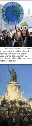  ?? CLAUDE PARIS — THE ASSOCIATED PRESS ?? A demonstrat­or holds a placard reading “Respect your earth as your sea” during an action for the climate in Marseille, southern France, Saturday.