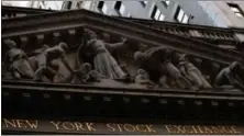  ?? MARY ALTAFFER — THE ASSOCIATED PRESS FILE ?? The New York Stock Exchange at sunset, in lower Manhattan. Global stock markets edged lower Wednesday as investors treaded carefully ahead of an annual gathering of central bankers.