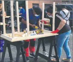  ??  ?? Volunteers build desks in Gaithersbu­rg.