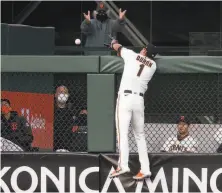  ?? D. Ross Cameron / Associated Press ?? Giants center fielder Mauricio Dubón leaps for a windblown fly by the Reds’ Jesse Winker that became a tworun homer.