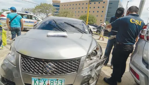  ?? SUNSTAR FOTO / ARNI ACLAO ?? HE DROVE. Investigat­ors check lawyer and Ronda Vice Mayor Jonnah John Ungab’s car just across Cebu City’s Hall of Justice (background) in the North Reclamatio­n Area. Ungab’s car hit a taxi after the attack.